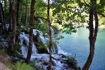 エメラルド色の湖と岩盤を流れる滝。